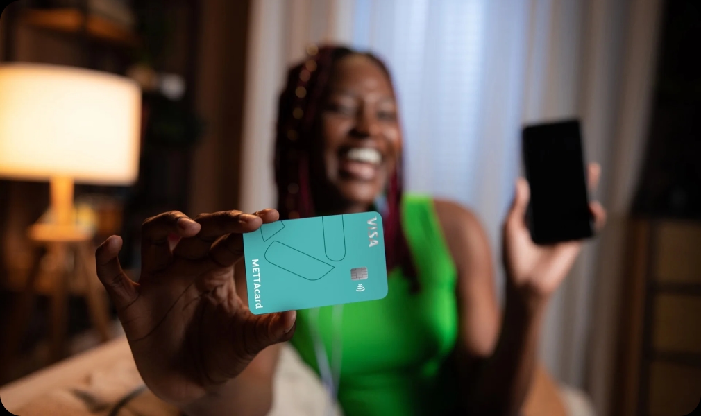 Jovem segurando cartão METTAcard